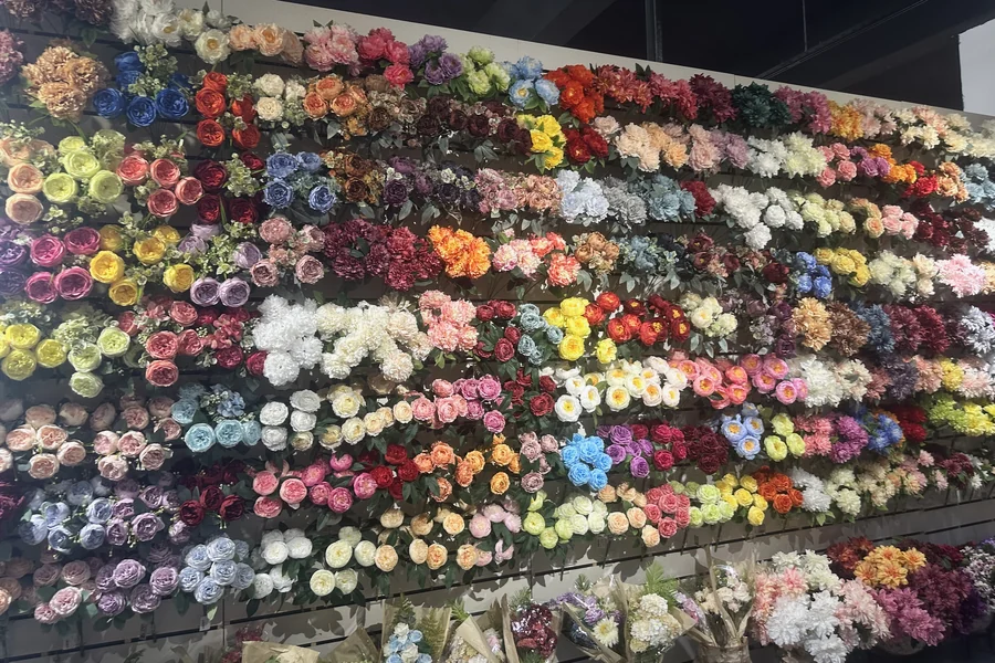 A showroom wall displaying artificial flower stems in a wide range of colors.