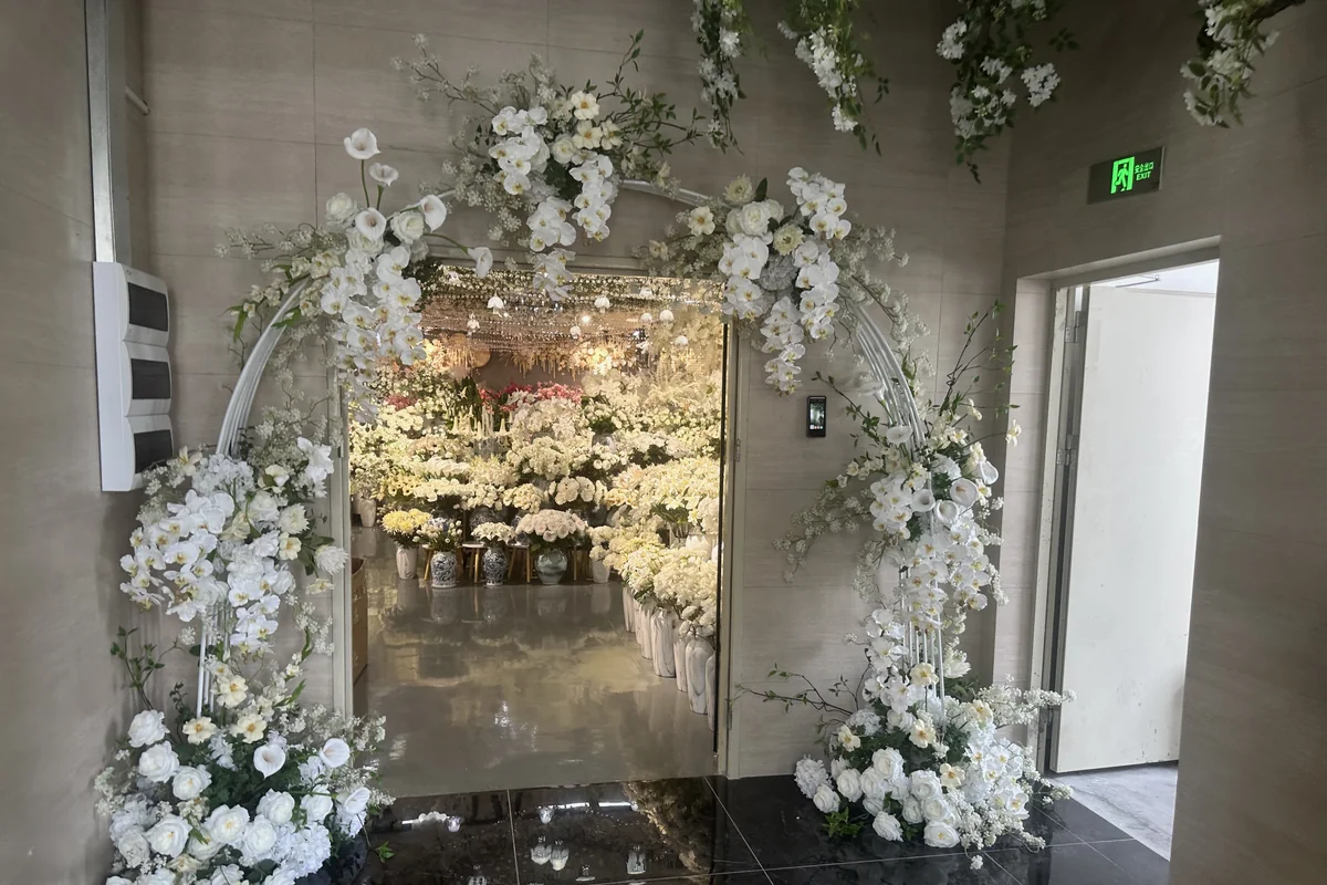 White artificial orchids and flowers framing the entrance to a retail floral showroom
